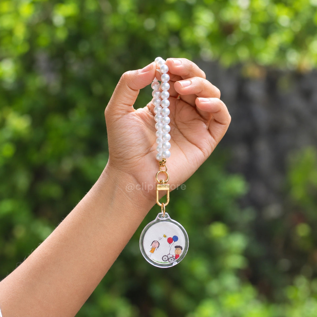 Pearl wristlet photo keychain held in a hand